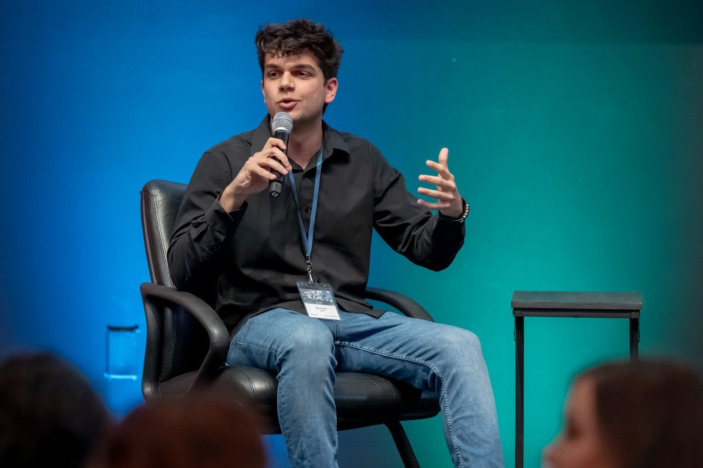 Eshan speaking on stage with a microphone